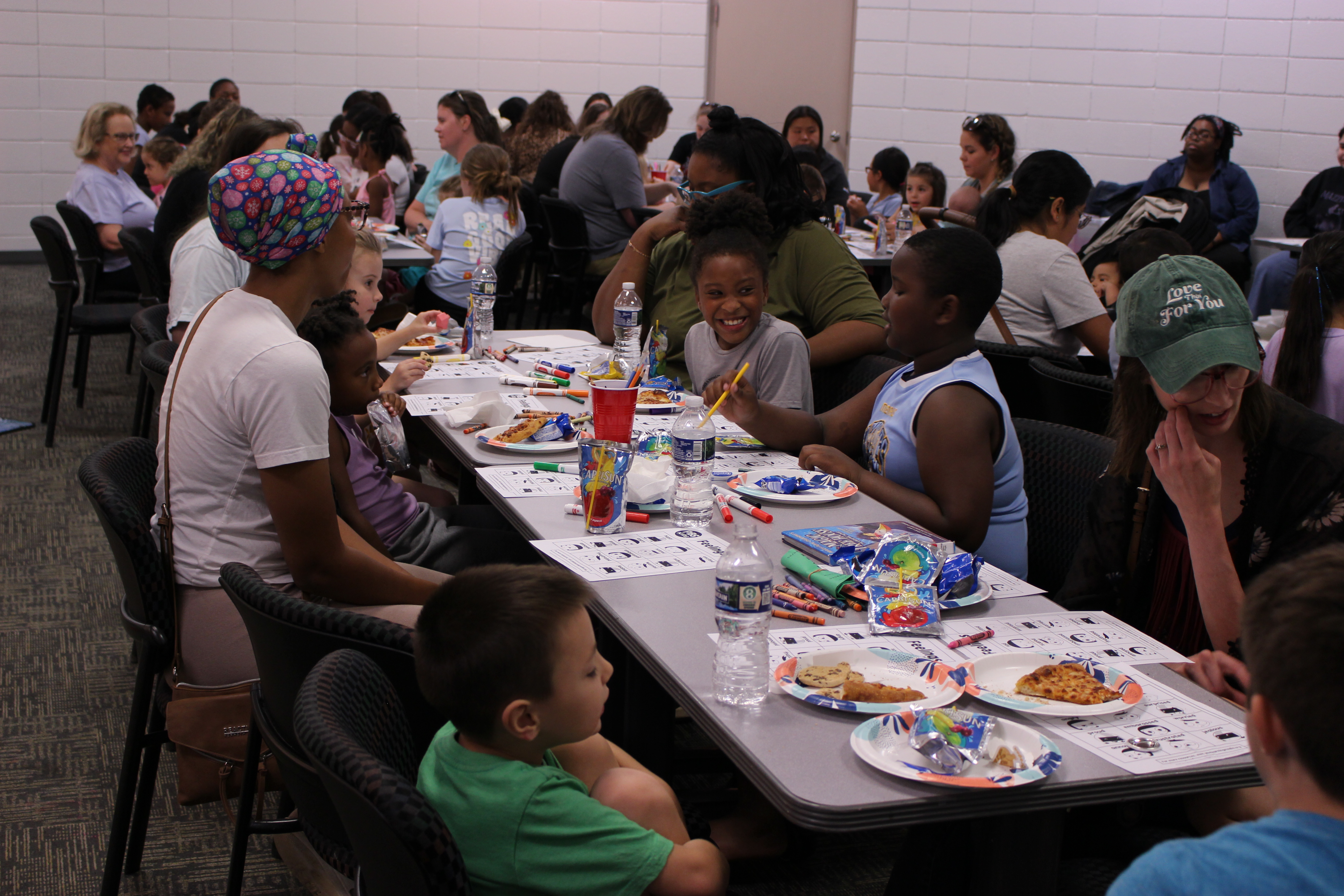 A Group of Parents and kids enjoying pizza and crafts at the PBS Storytime event