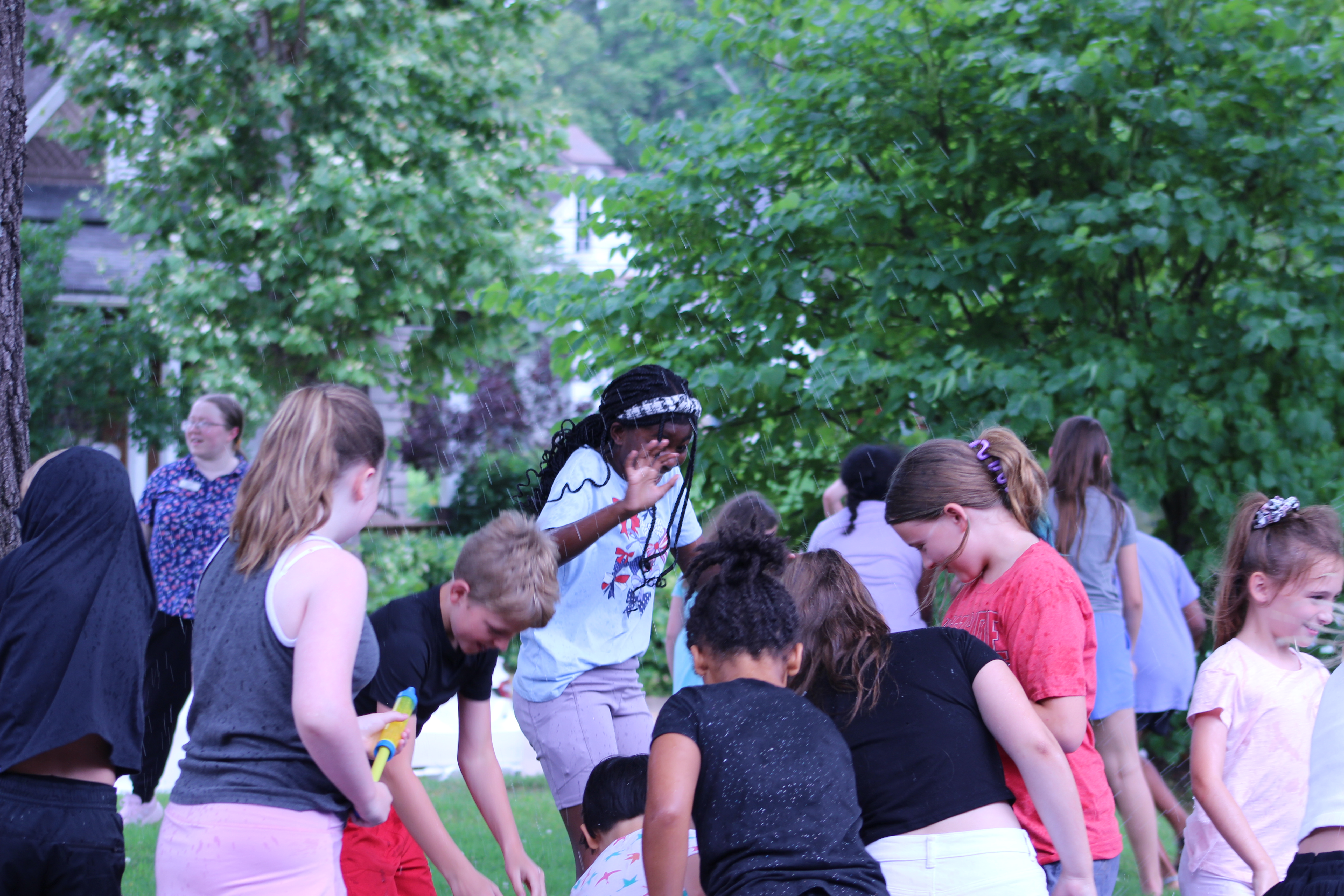 Tweens playing with water balloons out side of library