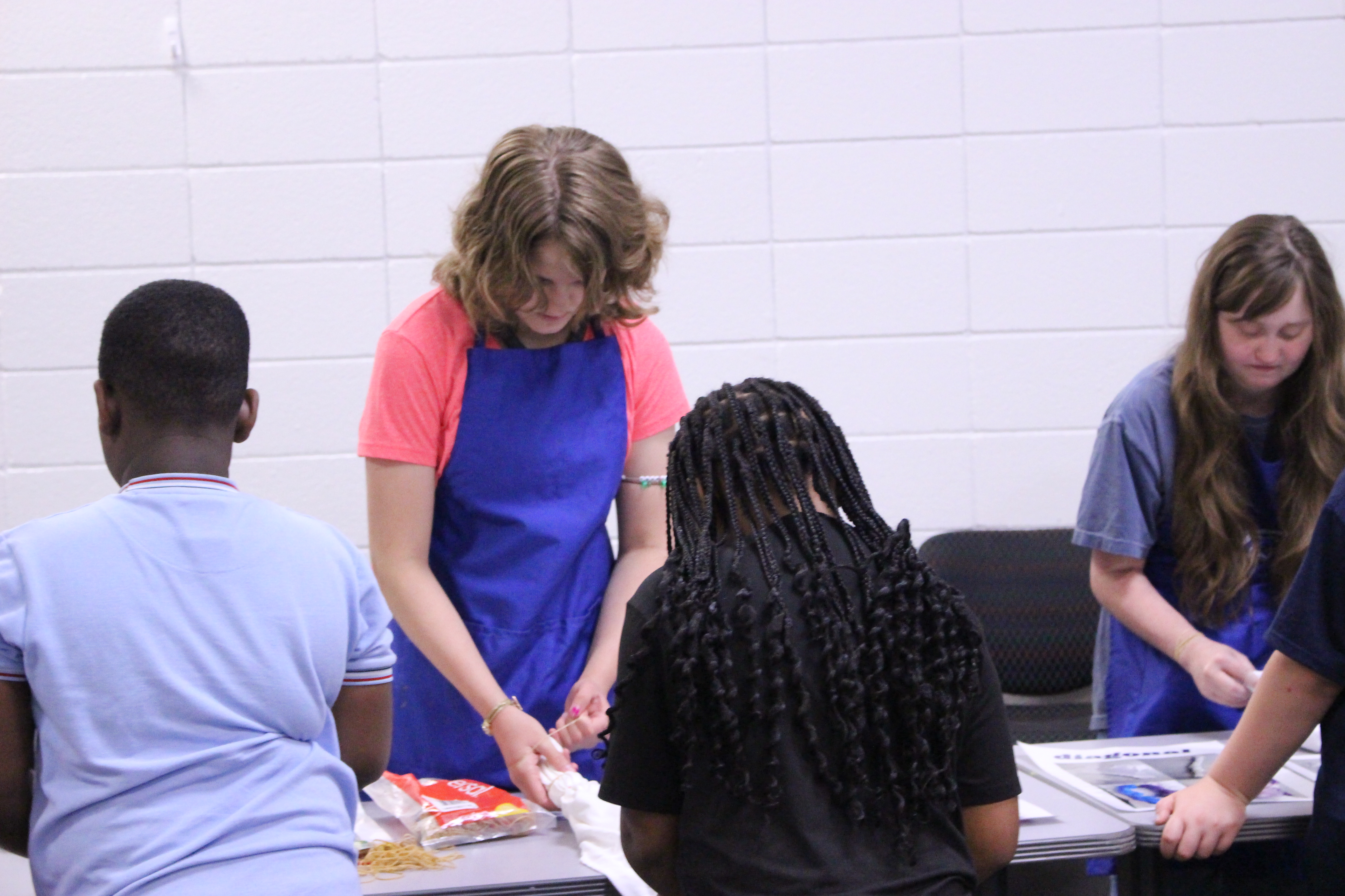 Volunteers helping children with tie dying shirts