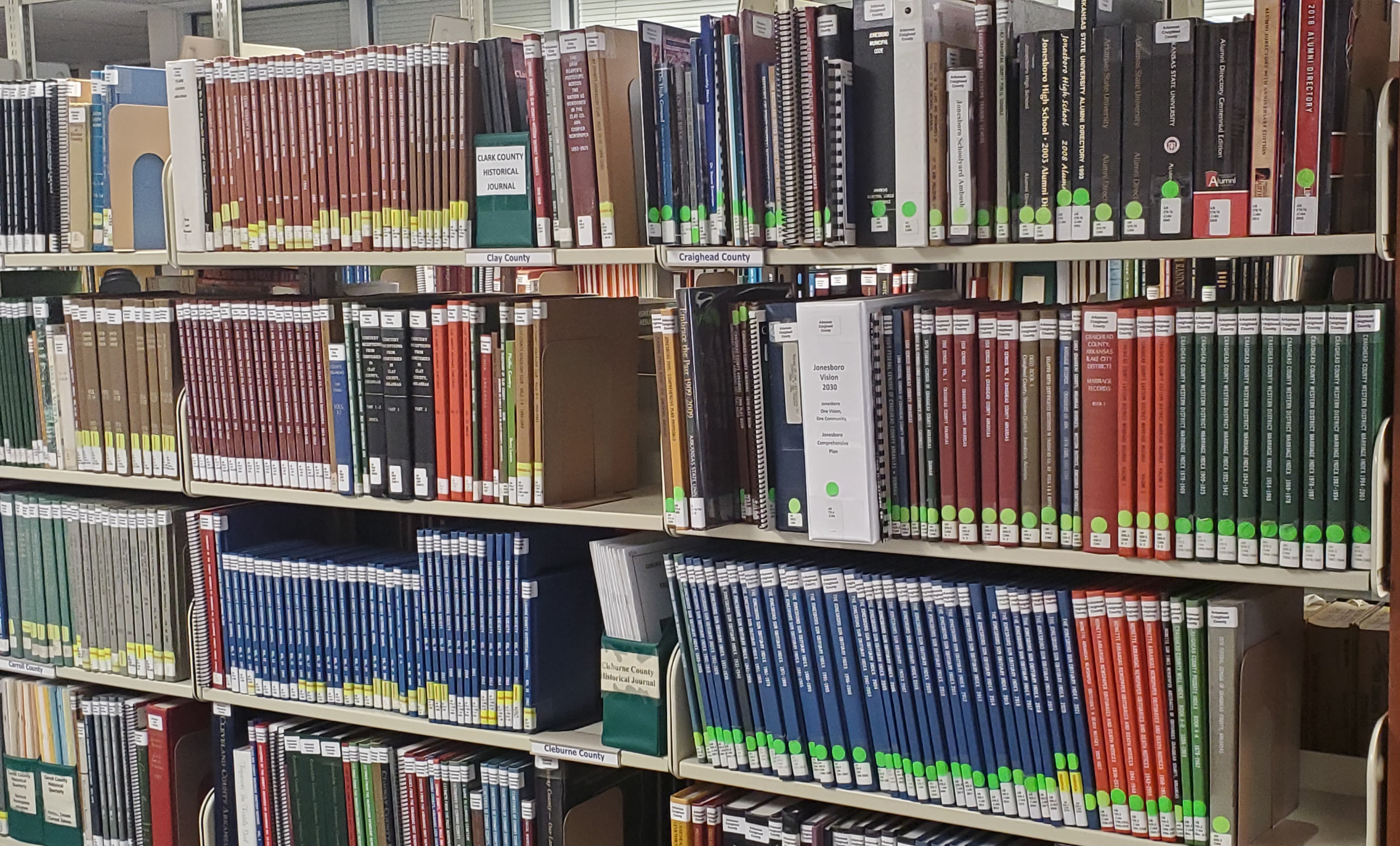 A picture of a bookshelf containing a considerable number of old, dusty books